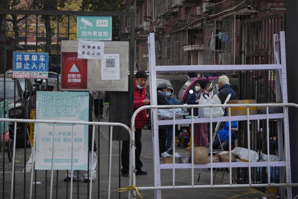همسایگان پشت نرده های قرنطینه در پکن باهم صحبت می کنند